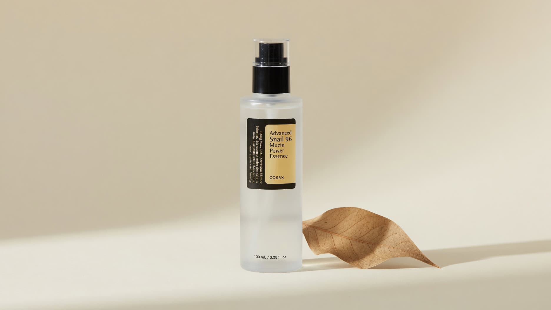 COSRX Snail Mucin Essence bottle on neutral background with snail shell accent