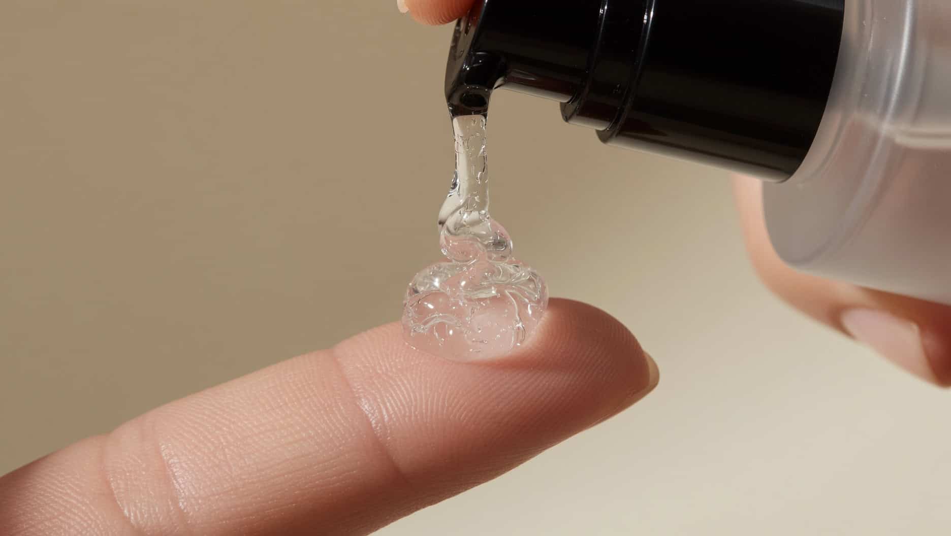 COSRX Snail Mucin Essence texture swatch on fingertip showing gel consistency