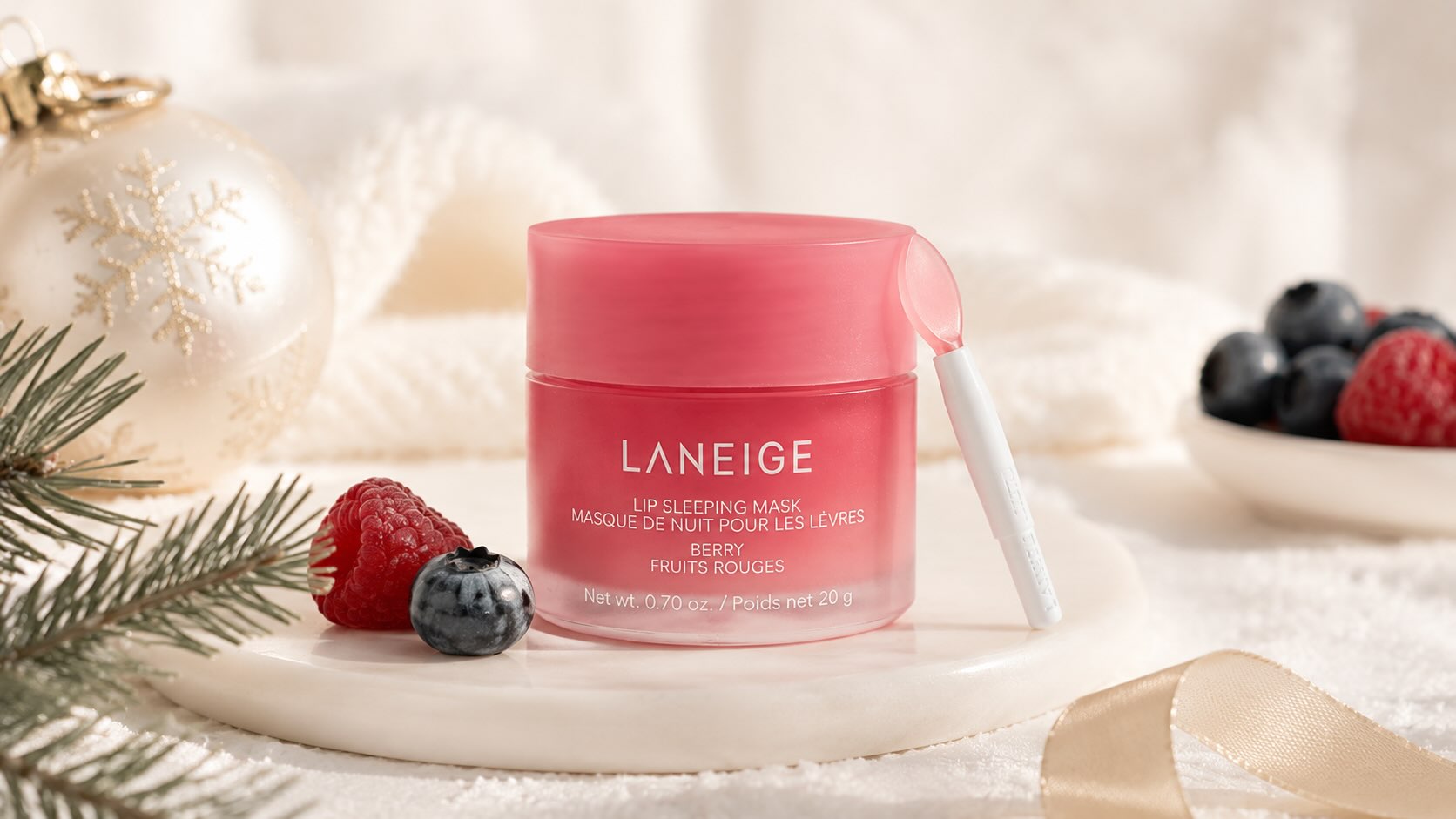 Laneige Lip Sleeping Mask pink jar with included applicator spatula on soft holiday background