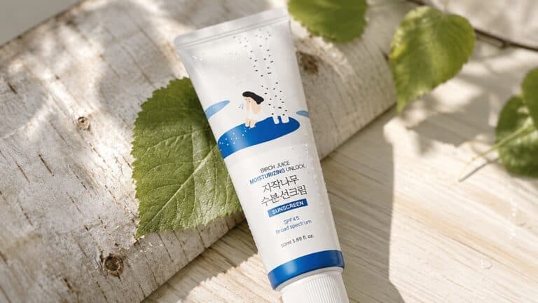 Round Lab Birch Juice Sunscreen tube on birch leaf with water droplets
