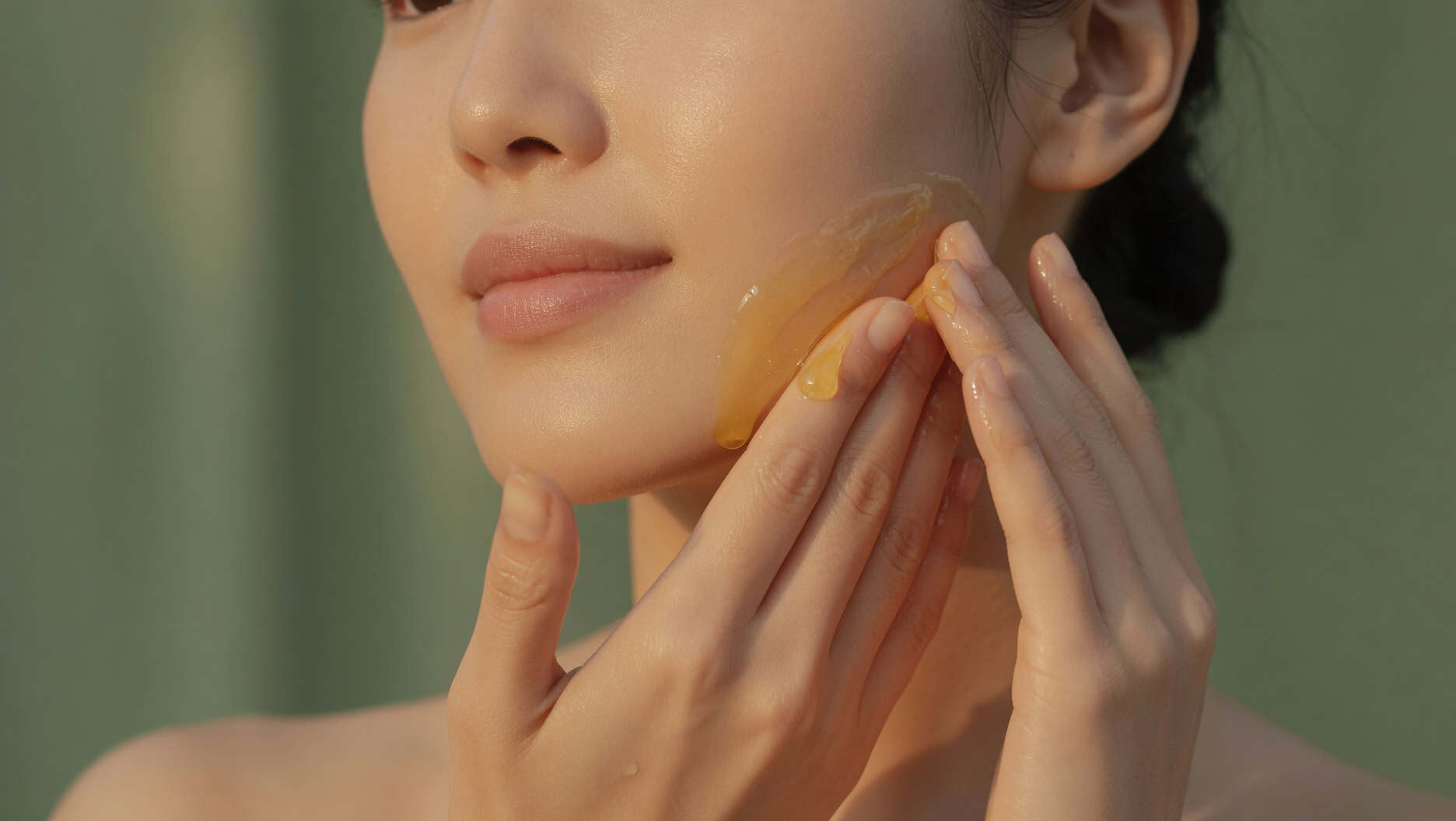 Hands pressing Skin1004 Centella Ampoule into facial skin during evening skincare routine