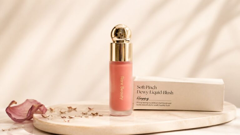 Rare Beauty Soft Pinch Liquid Blush bottle with rose petal on cream background