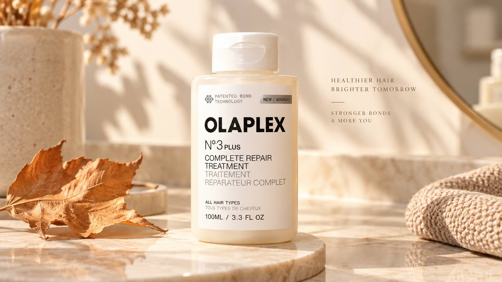 Olaplex No.3 Hair Perfector bottle on cream marble with autumn leaf — fall hair repair editorial