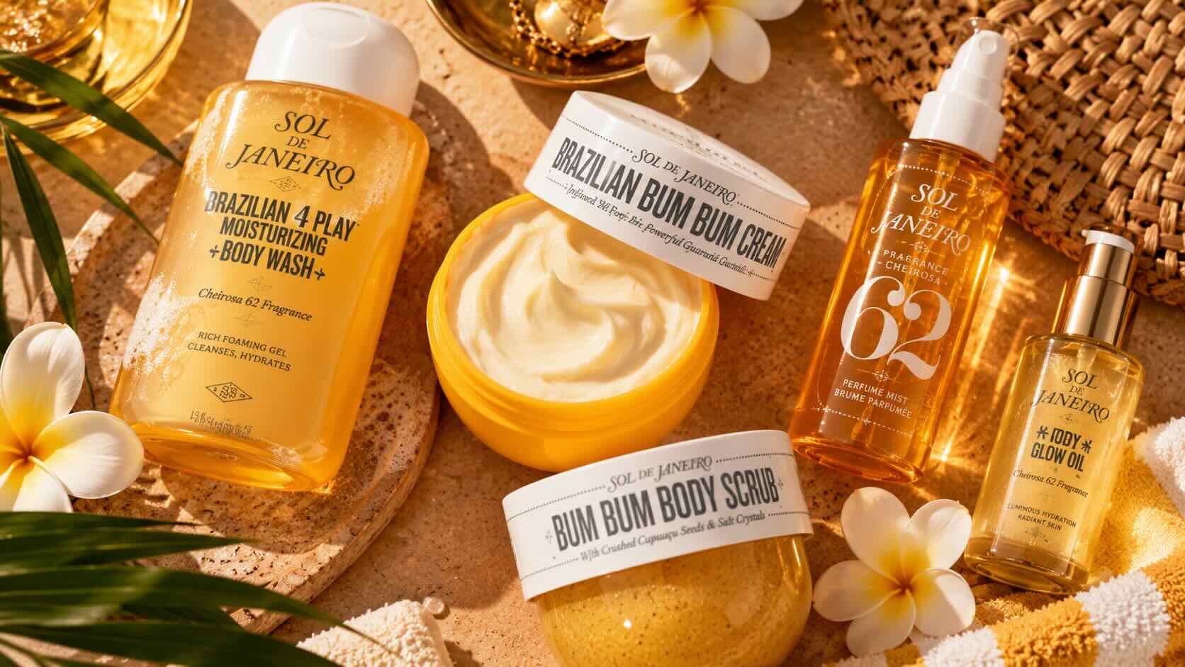 Sol de Janeiro Bum Bum Cream as part of a post-shower body care routine — yellow jar with body mist and loofah on warm bathroom editorial setting